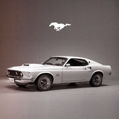 an old mustang car is shown in this black and white photo with the mustang logo above it