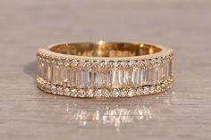 an image of a wedding ring with diamonds on the bottom and side stones in the middle