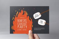 a hand holding up a bonfire cookout party card