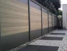 a long row of wooden slats next to a building with a fence on the side