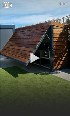 a house that is made out of wood and has a roof over the garage area