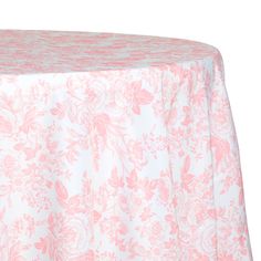 a pink and white table cloth with floral designs on the top, sitting on a round table