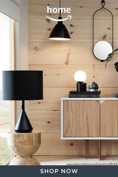 a living room with wood paneling and black lamps on the sideboard next to it