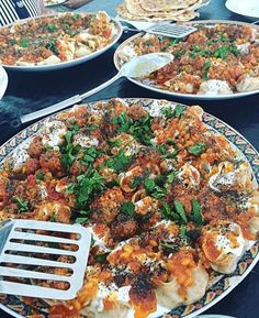 several plates of food are sitting on a table with utensils in front of them