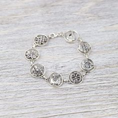 This sterling silver charm bracelet is a great way to accessorize and carry something incredibly meaningful with you throughout the day. Each charm depicts one of the 8 Auspicious Symbols, also known as the "Ashtamangala" in Sanskrit. "Ashta" meaning "eight," and "mangala" meaning "auspicious." Handmade by a fair-trade group of silversmiths in Nepal, this detailed bracelet is finished with a lobster clasp. In Buddhist legend, the 8 Auspicious Symbols represent offerings the gods made to the Budd Spiritual Sterling Silver Bracelets With Silver Clasp, Symbolic Sterling Silver Bracelet, Handmade Symbolic Silver Charm Bracelet, Symbolic Handmade Silver Charm Bracelet, Symbolic Nickel-free Silver Bracelets, Antique Silver Sterling Bracelet As Gift, Antique Silver Sterling Bracelet For Gifts, Antique Silver Round Sterling Silver Bracelet For Gift, Antique Silver Round Sterling Silver Bracelet Gift