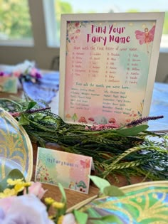 a table topped with cards and flowers next to a sign that says, find your fairy name