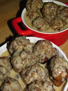 two bowls filled with meatballs and gravy on top of a wooden table