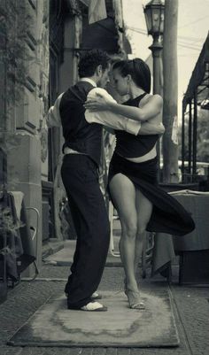 a man and woman are dancing on the street