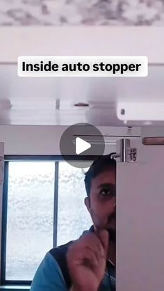 a man standing in front of a window with the words inside auto stopper