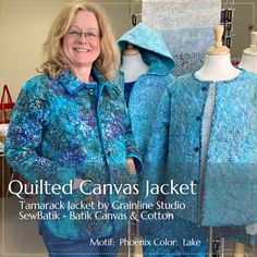 a woman standing next to two blue jackets on mannequins