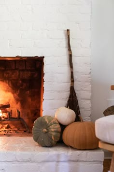 a fire place with pumpkins and other items on the fireplace mantel in front of it