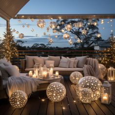 an outdoor living room with lights on the floor and decorations hanging from the ceiling above it