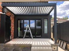 a black house with a metal roof and stairs leading up to the front door area