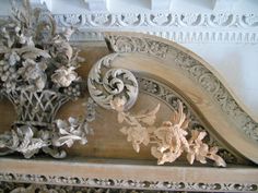 an intricately carved wooden shelf with flowers and leaves