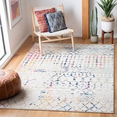 a living room area with a chair, rug and potted plant