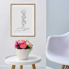 a vase with flowers sits on a table next to a chair and framed art piece