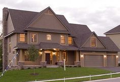 a large house with lots of windows and lights on it's front lawn area