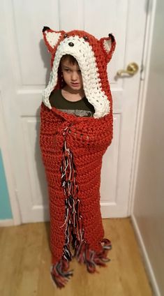 a little boy wearing a crocheted fox costume