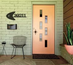 a pink door and chair in front of a white brick wall with a sign that reads 1230