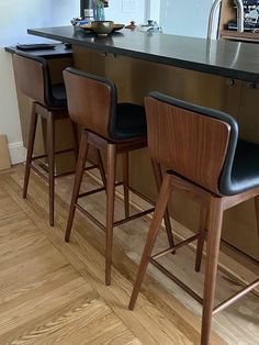 three bar stools sitting in front of an island