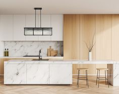 a modern kitchen with marble counter tops and white cabinets, along with wooden flooring