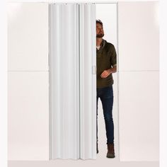 a man standing in front of a tall white door