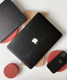 an apple laptop computer sitting on top of a table next to coasters and plates