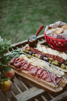 an assortment of meats and cheeses on a picnic table