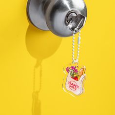 a key chain attached to a door handle with a flower pot hanging from it's side