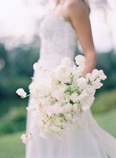 a bride holding a bouquet of white flowers