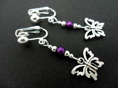 This a pair of pretty tibetan silver dangly butterfly clip on earrings. Measure approx. 4cm from top of hook to bottom of earring. These earrings are not for pierced ears. Freshly made by me and unworn. Thanks for looking!! Silver Butterfly Charm Drop Earrings, Purple Metal Dangle Earrings, Purple Dangle Metal Earrings, Silver Drop Earrings With Butterfly Charm, Adjustable Drop Earrings With Butterfly Charm, Adjustable Nickel-free Butterfly Jewelry, Adjustable Butterfly-shaped Nickel-free Jewelry, Adjustable Butterfly Jewelry Nickel Free, Nickel-free Adjustable Butterfly Earrings