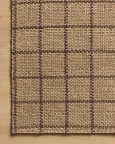 a brown and tan area rug on top of a wooden floor