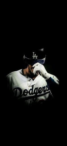 a baseball player in the dark with his head resting on his hand and wearing a hat