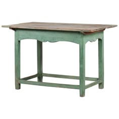 an old green table with wooden top