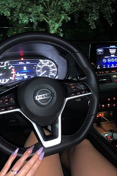 a woman is sitting in the driver's seat of a car with her hands on the steering wheel