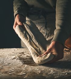 a person kneading dough on top of a table