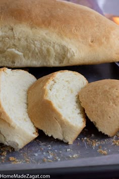 a loaf of bread sitting on top of a pan next to some slices of bread