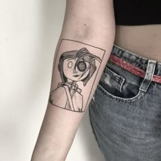 a woman's arm with a cartoon character tattoo on the left side of her right arm