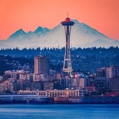 the space needle in seattle, washington state at sunset with mt rainier in the background