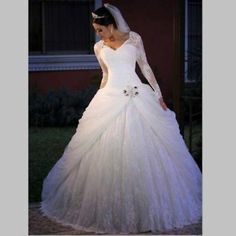 a woman in a white wedding dress standing outside