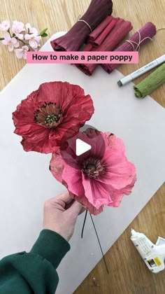 someone is making paper poppys on the table