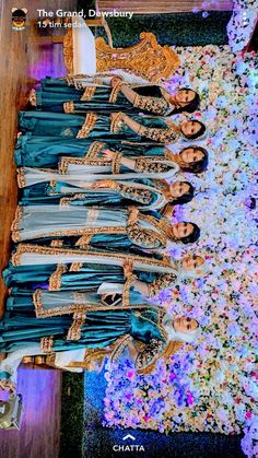 a group of women standing next to each other in front of a flower covered floor