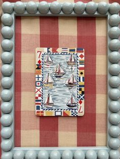 a painting with some boats in the water on it's side and a checkered background