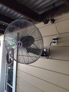 a fan is hanging on the side of a house