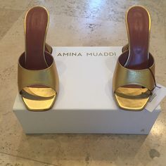 New, In Original Box, Amina Muaddi Lupita Slipper Sandals In Gold In Size 40 - Rare Color And Sold Out Worldwide! - Leather Upper And Sole - Made In Italy - Square Toe - Original Box And Dustbag Included ** Slight/Faint Mark On The Bottom Of One Sole From Trying On The Shoe On Tile At Home - As Pictured On Last Photo. Designer Gold Sandals With Wrapped Heel, Gold Square Toe Sandals For Evening, Gold Square Toe Evening Sandals, Gold Open Heel Mules For Evening, Luxury Gold Mules For Party, Gold Mules With Padded Block Heel, Designer Gold Sandals With Square Toe, Gold Leather Mules With Padded Heel, Gold Square Toe Sandals For Party