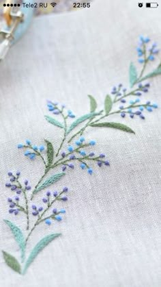 an embroidered piece of cloth with blue flowers on it