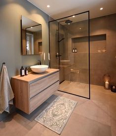 a bathroom with a sink, mirror and shower stall in it's own area