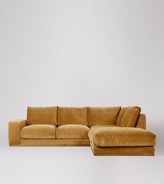 a large yellow couch sitting on top of a white floor