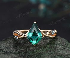 an emerald colored ring sitting on top of a rock