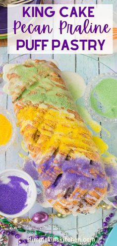 a piece of cake on a plate with purple and yellow icing next to it